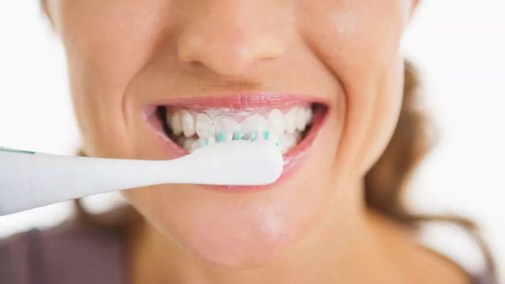 mulher escovando os dentes com creme dental clareador